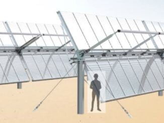 Person standing near a large solar panel structure with support beams.