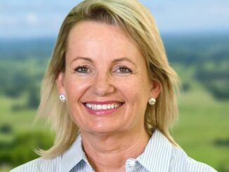 Smiling middle-aged woman outdoors with a natural background.