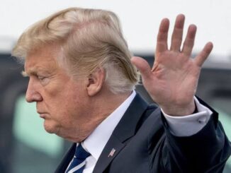 Side profile of a man raising his hand.