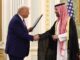 Donald Trump shaking hands with a Saudi royal in traditional attire.