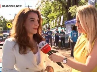 Two women engaged in an outdoor interview under sunny conditions.