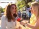 Two women engaged in an outdoor interview under sunny conditions.