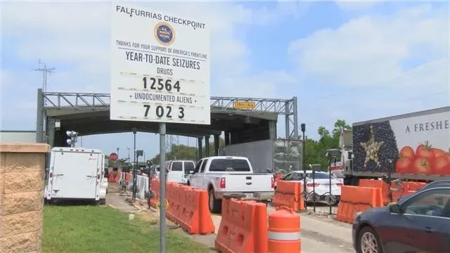 Line of vehicles at a toll plaza with fee details displayed.
