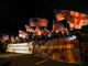 Crowd holding American and Georgian flags at night with supportive banners.