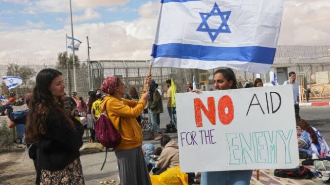 Protesters with Israeli flag and 'No Apartheid' sign.