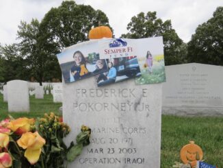 A decorated gravestone with photos and flowers honoring a deceased individual.