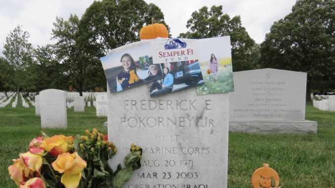 A decorated gravestone with photos and flowers honoring a deceased individual. A decorated gravestone with photos and flowers honoring a deceased individual.