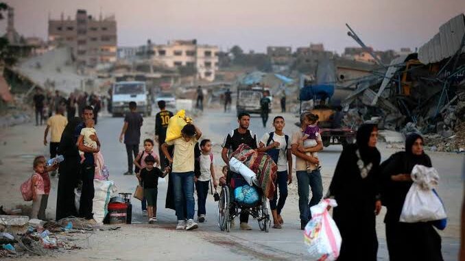 Group of people walking on a dusty road with bags and belongings. Group of people walking on a dusty road with bags and belongings.