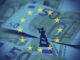 A toy soldier standing on Euro banknotes with EU stars.