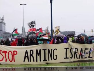 Protesters holding a banner saying 'Stop Arming Israel' with Palestinian flags.