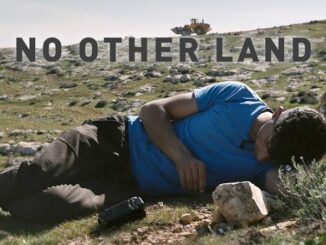 Man lying on rocky terrain holding his chest in pain.
