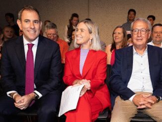 Three people sitting and smiling at an event.