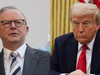 Two men in suits, one speaking and the other listening intently.