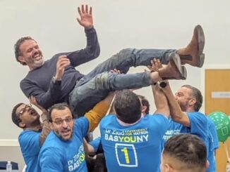 Group lifting a man in celebration, showing joy and teamwork.