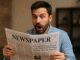Man shocked while reading a newspaper.