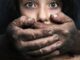 A distressed woman with a dirty hand covering her mouth.