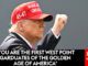 A man in a red 'Make America Great Again' hat raising his fist.
