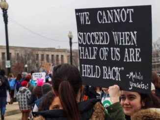 Protesters holding a sign about unity and success.