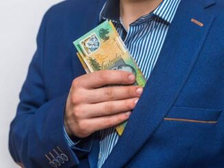 Person in blue suit pocketing cash discreetly.