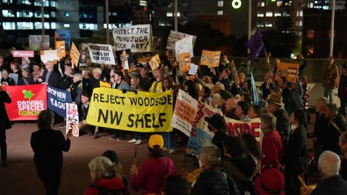 Crowd protesting with signs at night in an urban area. Crowd protesting with signs at night in an urban area.