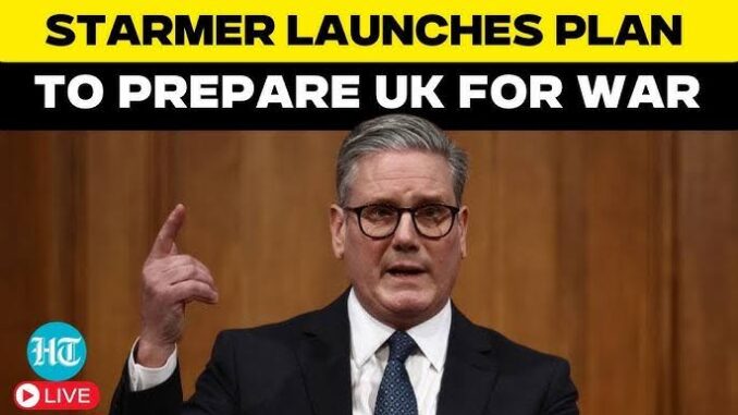A man in a suit speaks passionately at a podium with bold text about preparing the UK for a crisis.