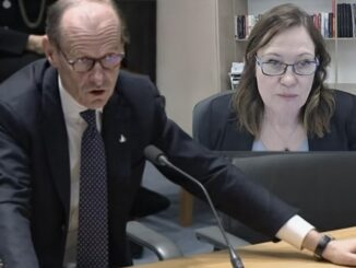 Two professionals engaged in a serious discussion at a meeting.