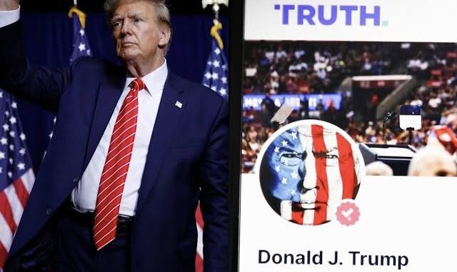 Donald Trump standing near a campaign poster with American flags. Donald Trump standing near a campaign poster with American flags.