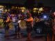 Sheriff deputies in tactical gear stand alert at night during a security operation.