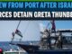 A boat with people and flags at sea with a headline about Greta Thunberg.