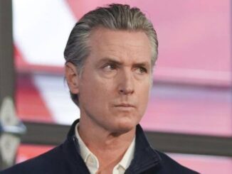 Portrait of a serious man with gray hair and a collared shirt.