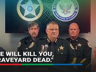 Three stern law enforcement officers at a press briefing.
