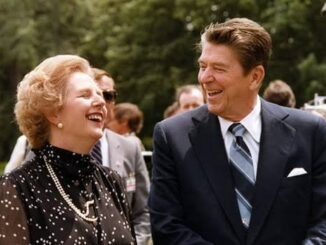 Two people dressed formally, sharing a joyful moment outdoors.