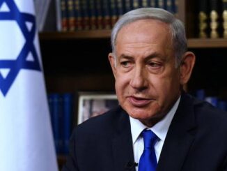 Portrait of a serious man in a suit with an Israeli flag in the background.