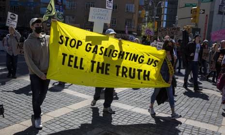 Protesters hold a yellow banner demanding truth about gaslighting. Protesters hold a yellow banner demanding truth about gaslighting.