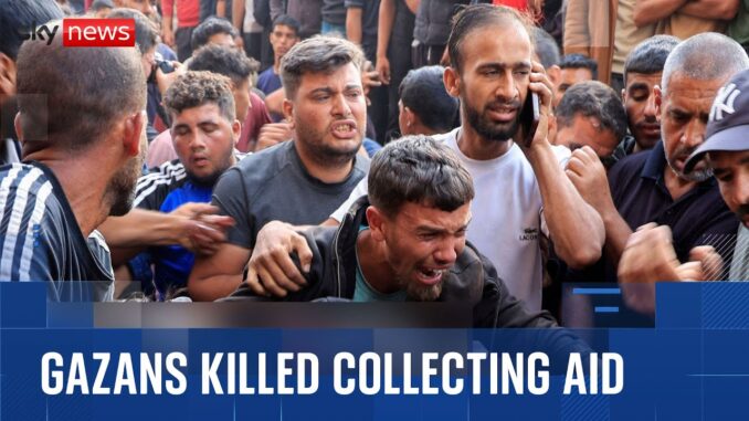 A group mourns over a man killed while collecting aid. A group mourns over a man killed while collecting aid.