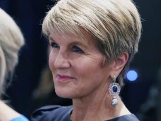 Elegant woman with short blonde hair and statement earrings.