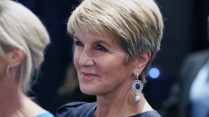 Elegant woman with short blonde hair and statement earrings.