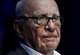 Close-up of an elderly man with glasses and a serious expression.