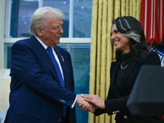 Two people shaking hands in a formal setting, smiling.
