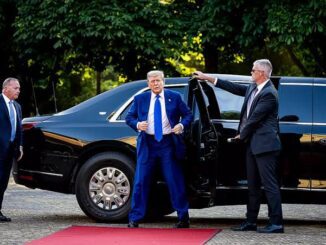 A man stepping out of a luxury car on a red carpet.