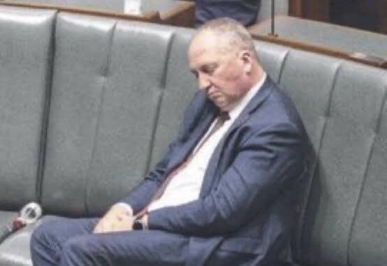 Man in a suit sleeping on a bench.