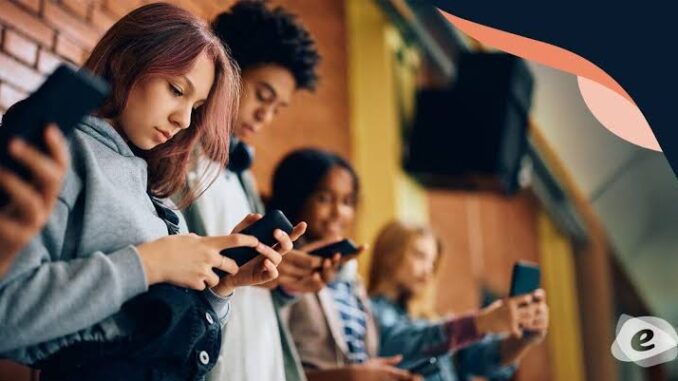 Young people focused on their smartphones while sitting together. Young people focused on their smartphones while sitting together.