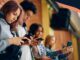 Young people focused on their smartphones while sitting together.