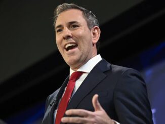 A man in a suit speaking passionately with a smile.