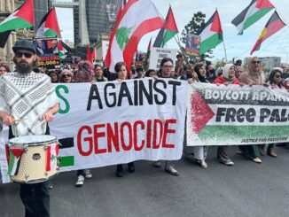 Protesters holding banners against genocide and advocating for boycott and freedom.