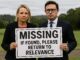 Two people holding "Missing" sign outdoors.