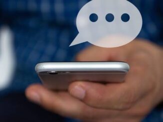 Person holding smartphone with a floating chat bubble above it.