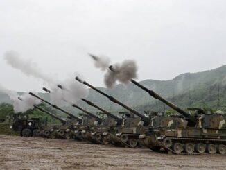 Military tanks firing in a mountainous area.
