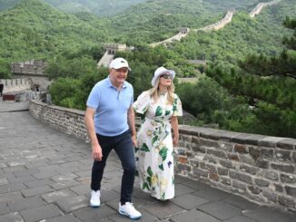 Couple walking on the Great Wall, smiling.