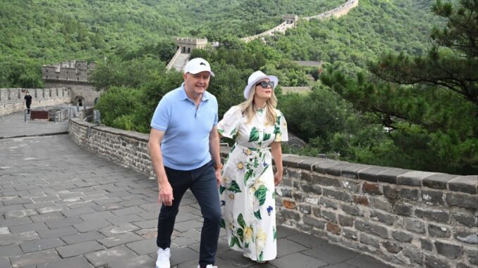 Couple walking on the Great Wall, smiling.